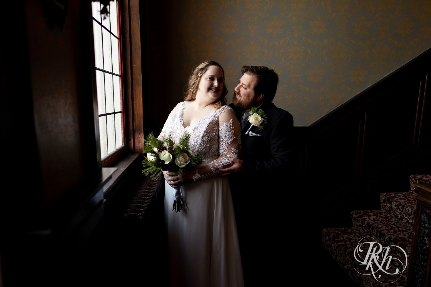 Bride and groom smiling next to window at Semple Mansion in Minneapolis, Minnesota.