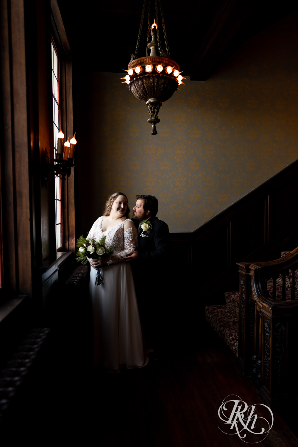 Bride and groom smiling next to window at Semple Mansion in Minneapolis, Minnesota.