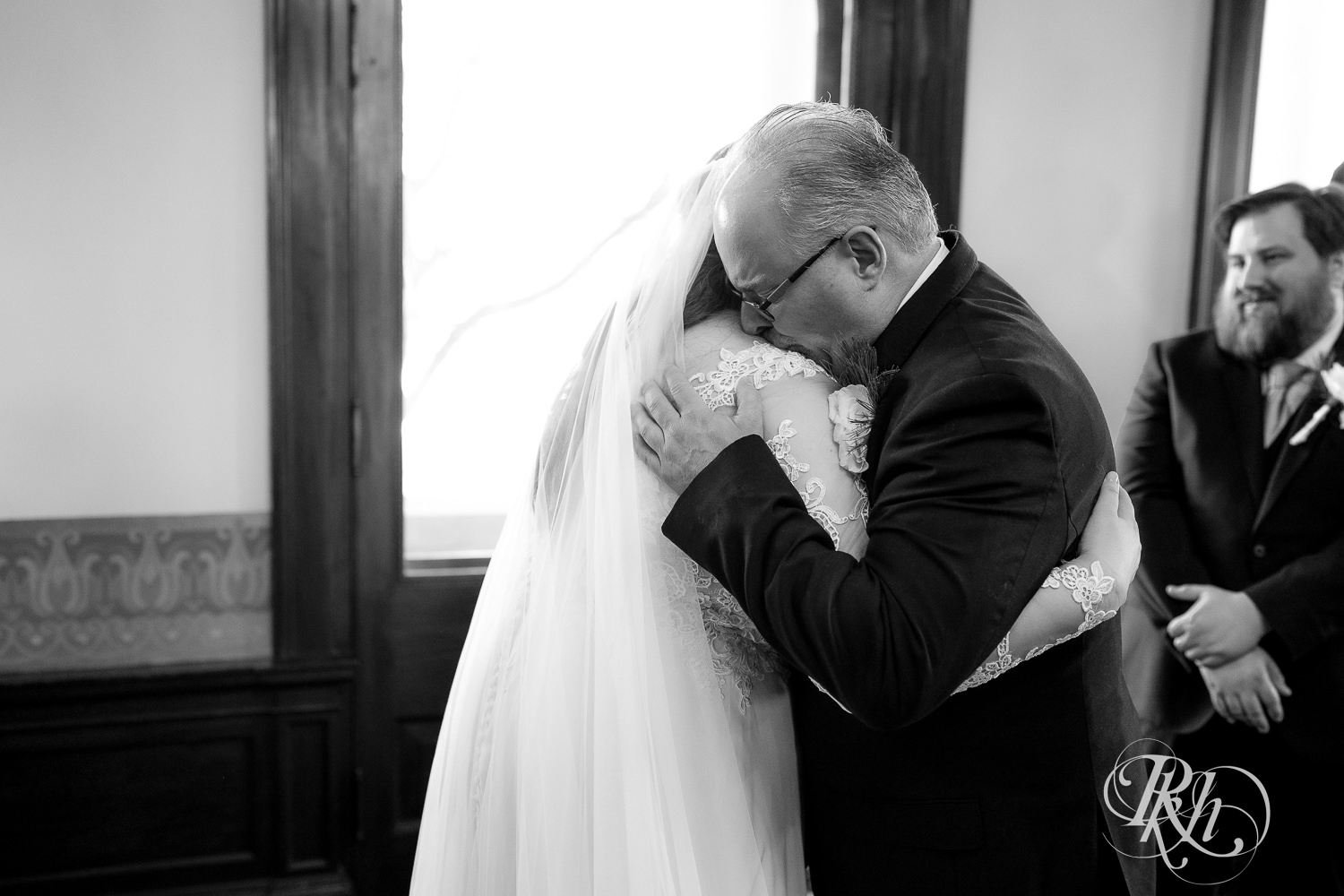 Dad hugging bride at alter at the wedding ceremony at Semple Mansion in Minneapolis, Minnesota.