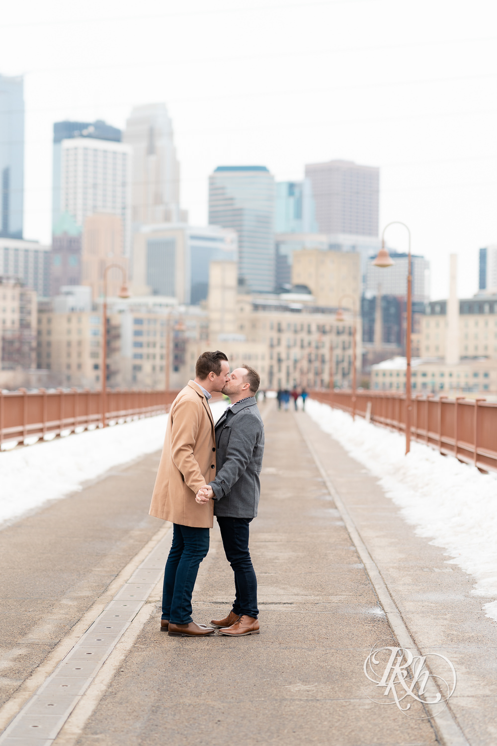 Gay men kiss on the Stone Arch Bridge during the winter in Minneapolis, Minnesota.