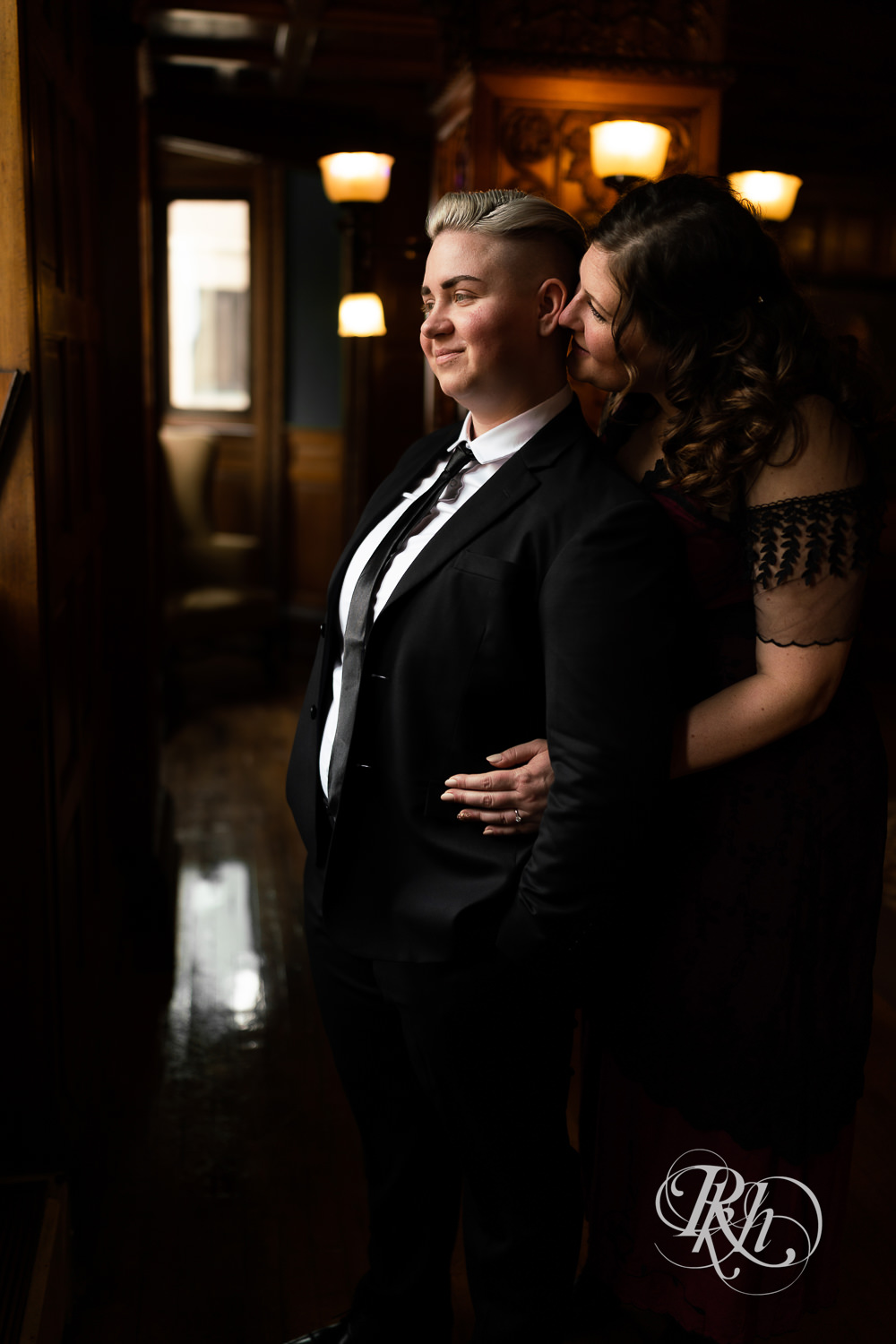 Lesbians smile dressed in Titanic dress and suit in Landmark Center in Saint Paul, Minnesota.