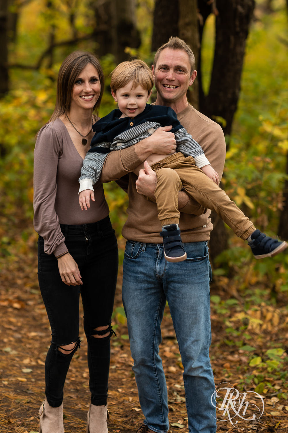 Minnesota fall family photography of little boy laughing with parents at Whitetail Woods in Farmington, Minnesota.