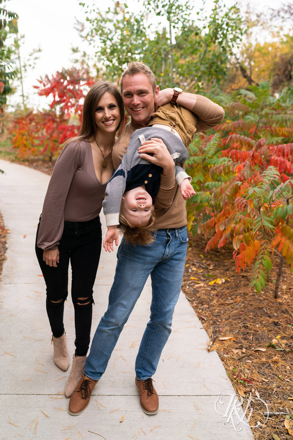 Minnesota fall family photography of little boy laughing with parents at Whitetail Woods in Farmington, Minnesota.