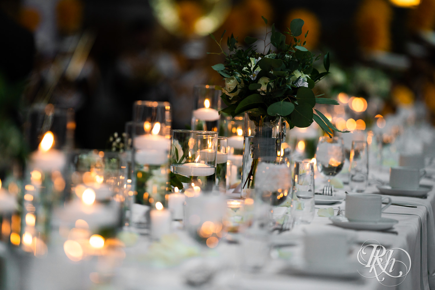 Head table setup with lots of candles and flowers at Doubletree Hilton Saint Paul in Saint Paul, Minnesota.