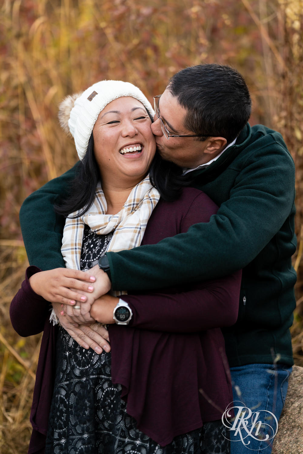 Man and Korean woman laugh in fall colors at Lebanon Hills Regional Park in Eagan, Minnesota.