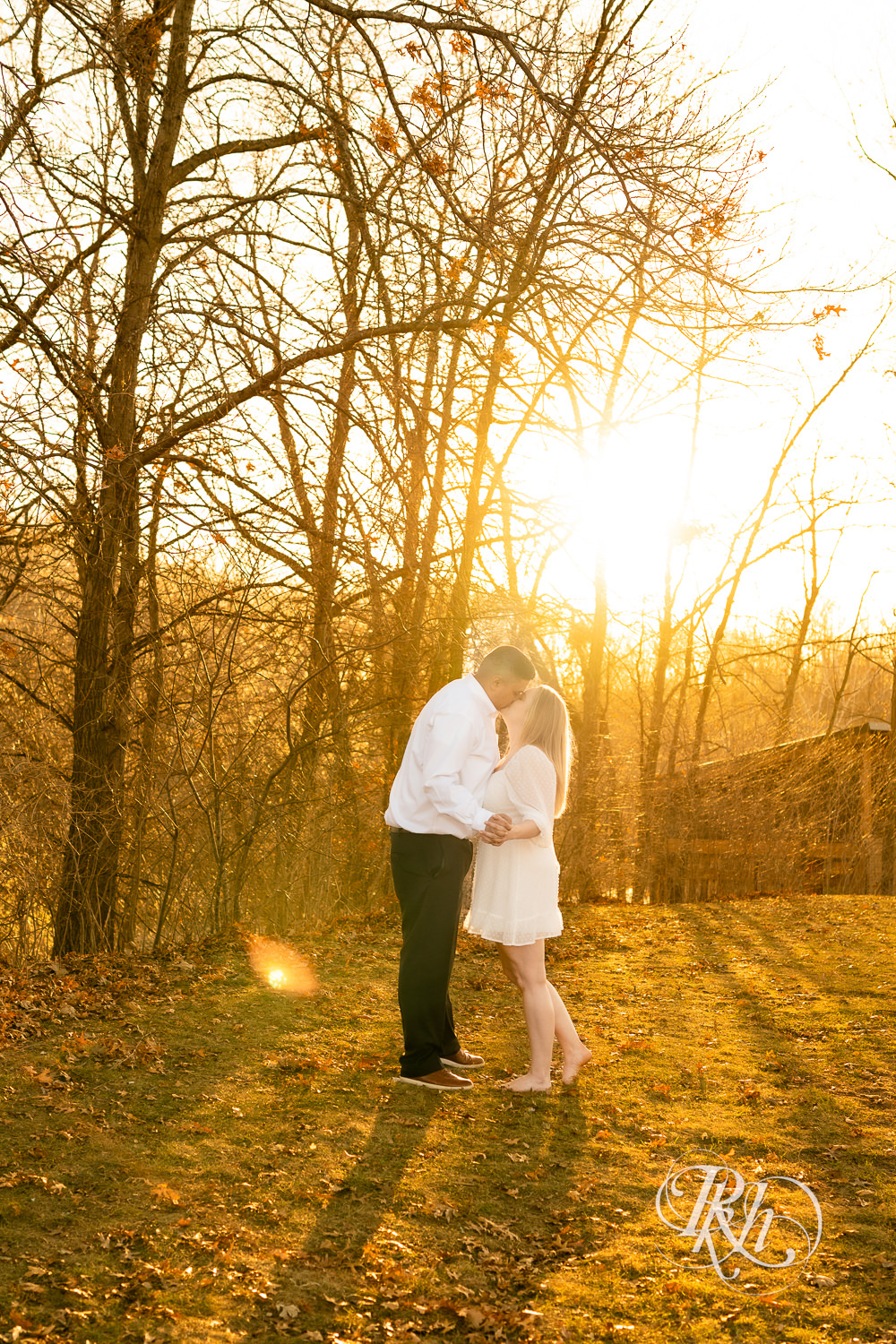 Filipino man and woman in white dress kiss during sunset at Lebanon Hills in Eagan, Minnesota.
