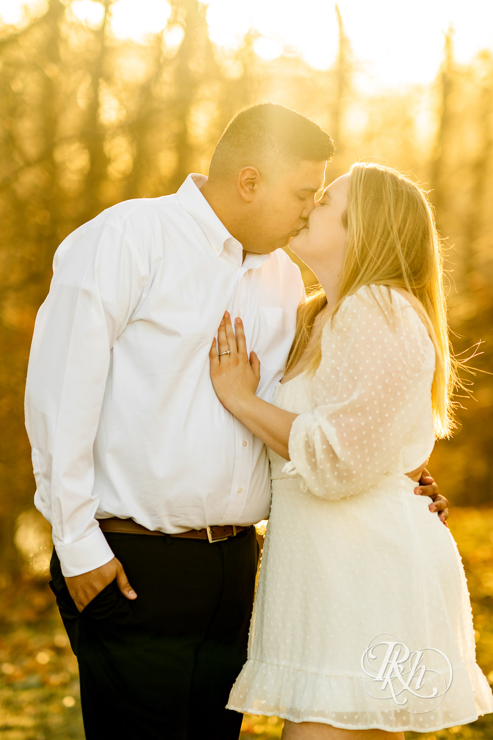 Filipino man and woman in white dress kiss during sunset at Lebanon Hills in Eagan, Minnesota.