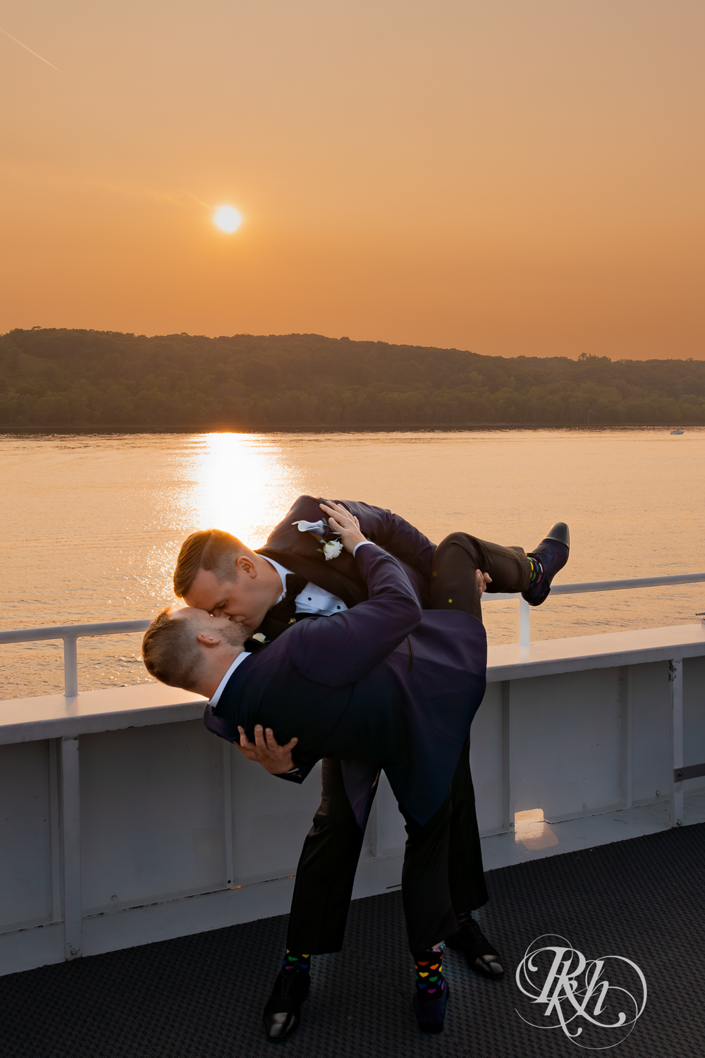Grooms kiss during sunset on the Majestic Star by Stillwater River Boats in Stillwater, Minnesota.