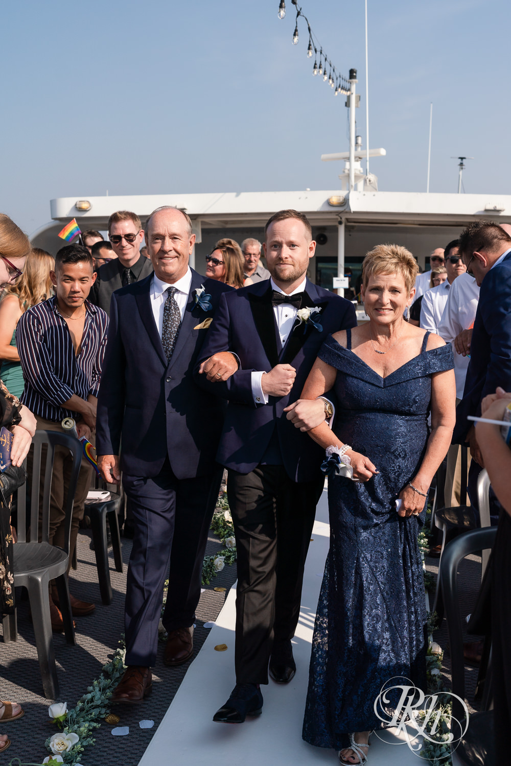 Grooms walk down the aisle with parents on the Majestic Star by Stillwater River Boats in Stillwater, Minnesota.
