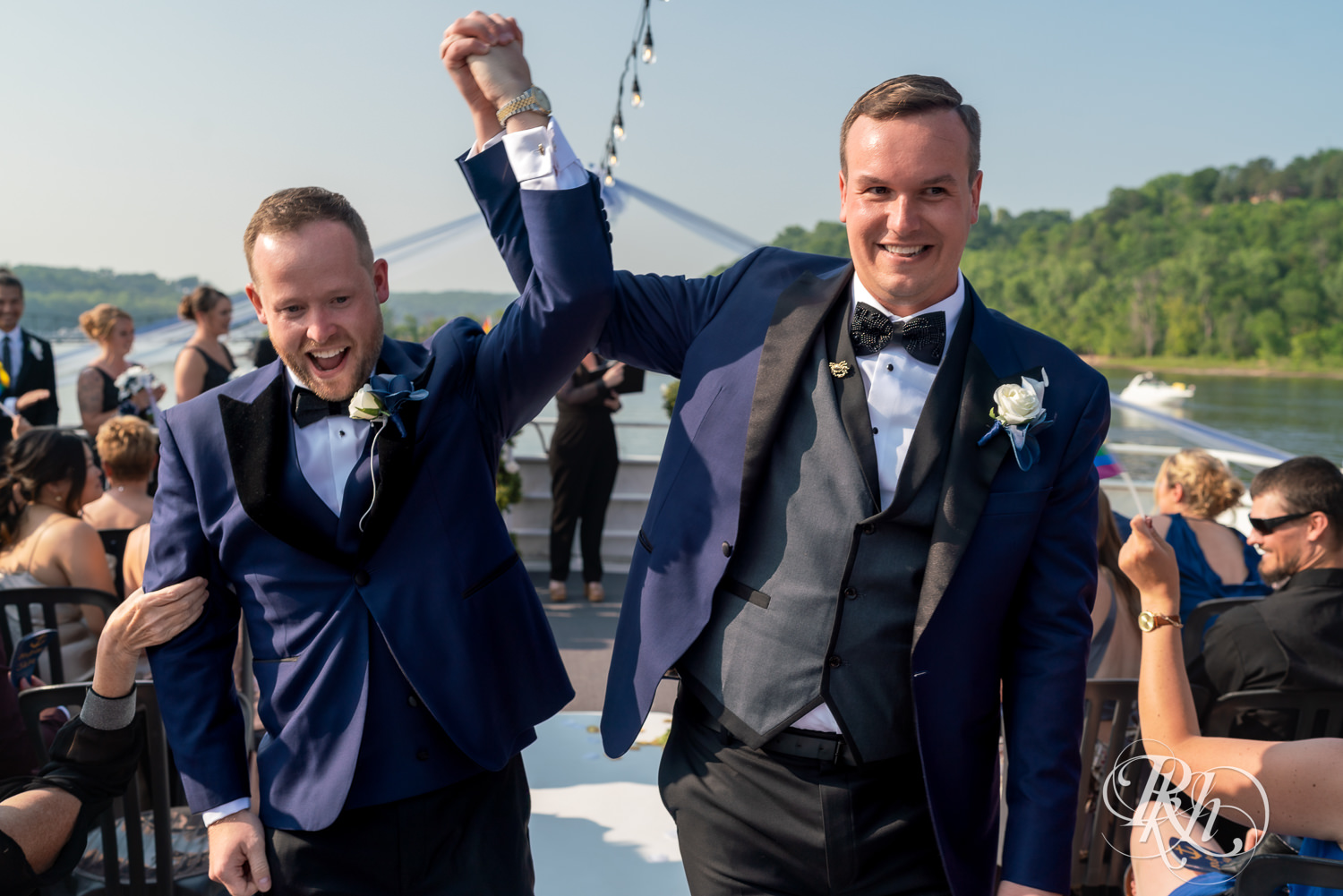 Grooms cheer after wedding ceremony on the Majestic Star by Stillwater River Boats in Stillwater, Minnesota.