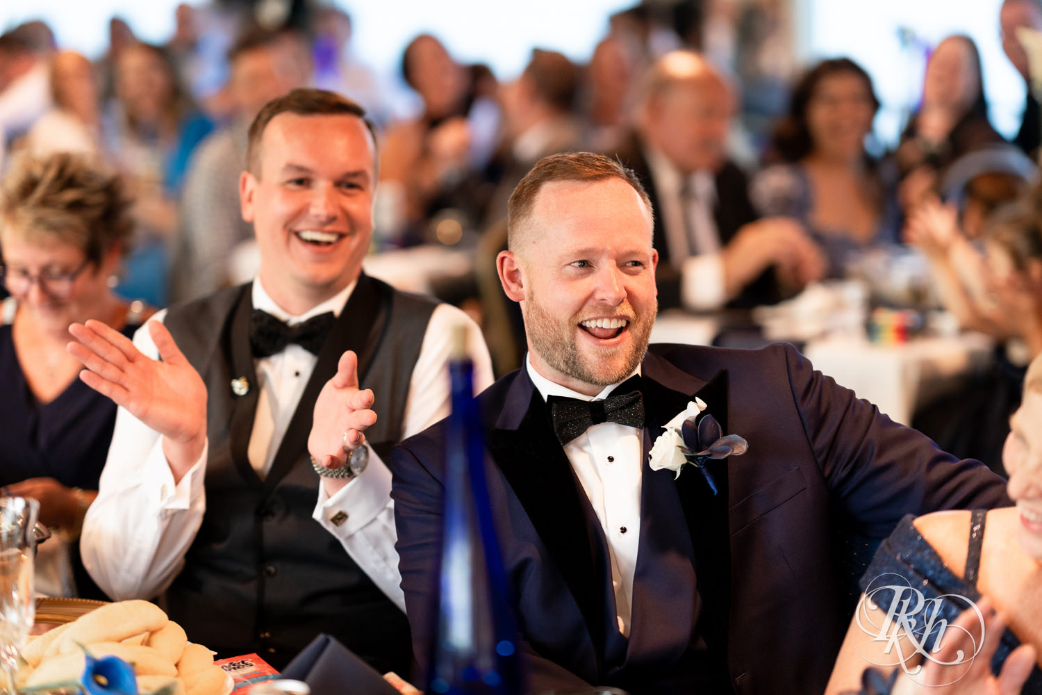 Grooms smile during speeches on the Majestic Star by Stillwater River Boats in Stillwater, Minnesota.