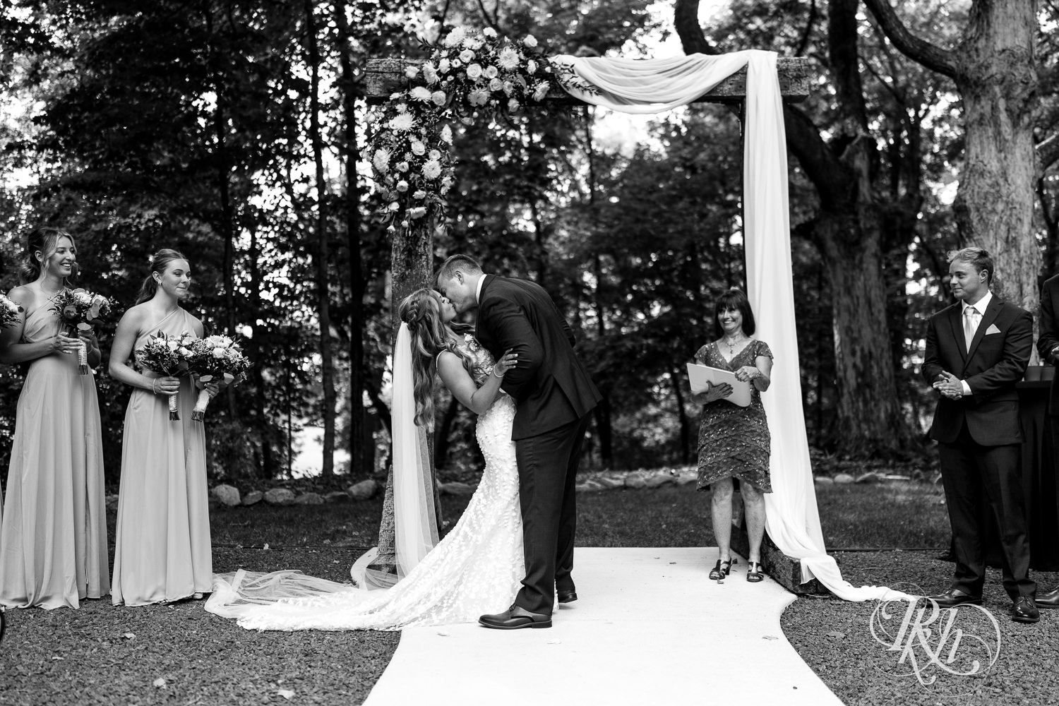 Bride and groom kiss during wedding ceremony on wedding day at Ahavah Cottage in Elysian, Minnesota.