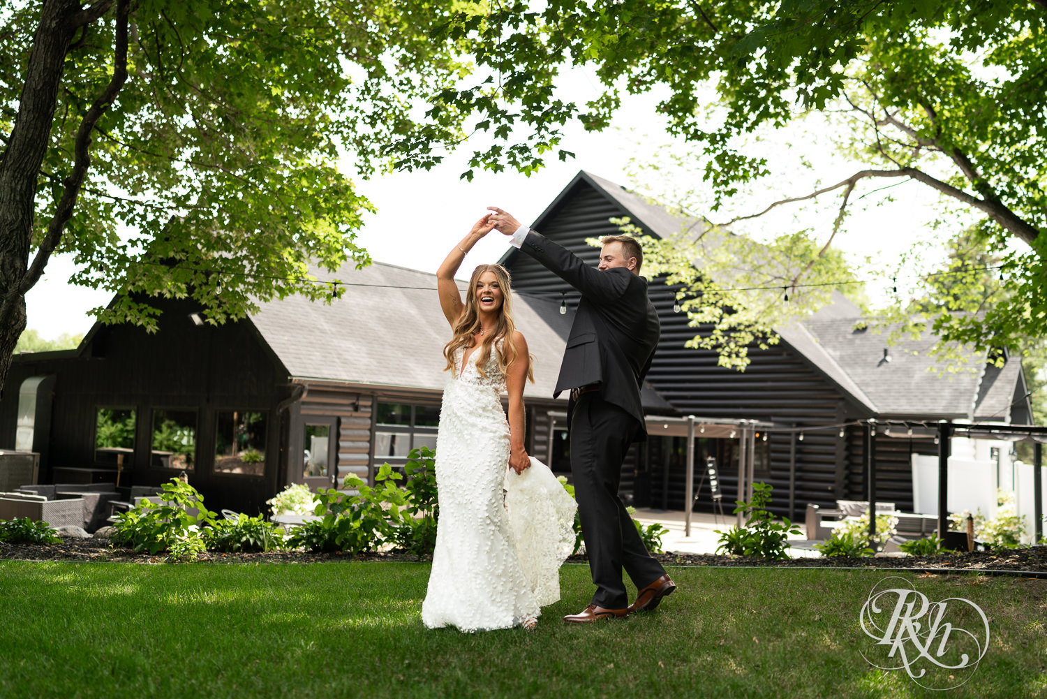 Bride and groom dance in the grass on wedding day at Ahavah Cottage in Elysian, Minnesota.