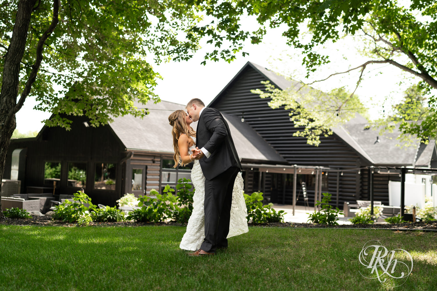 Bride and groom dance in the grass on wedding day at Ahavah Cottage in Elysian, Minnesota.