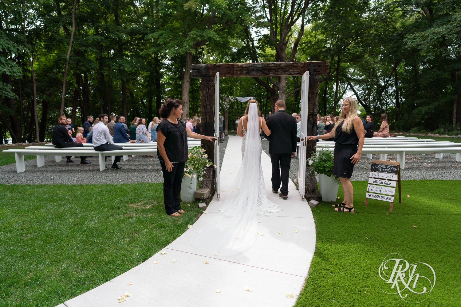 Bride walks down down aisle with dad on wedding day at Ahavah Cottage in Elysian, Minnesota.