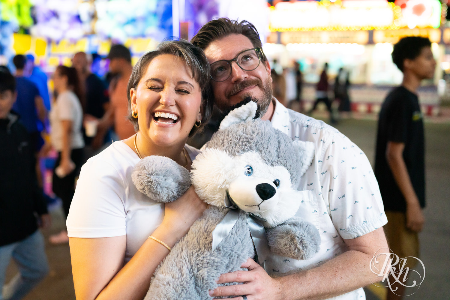 Man and woman laugh during their engagement photography at the Minnesota State Fair. 