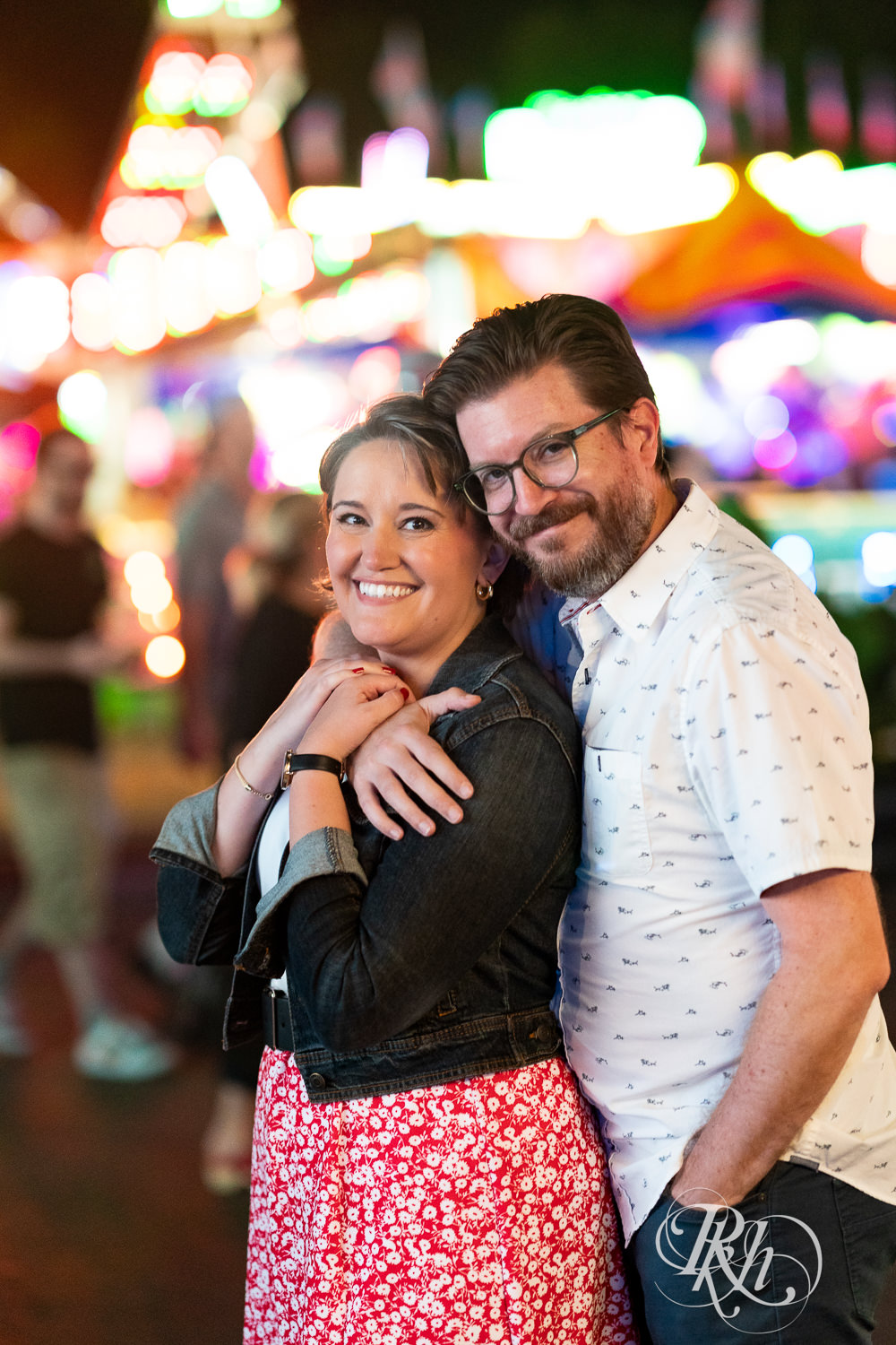 Man and woman smile during their engagement photography at the Minnesota State Fair. 