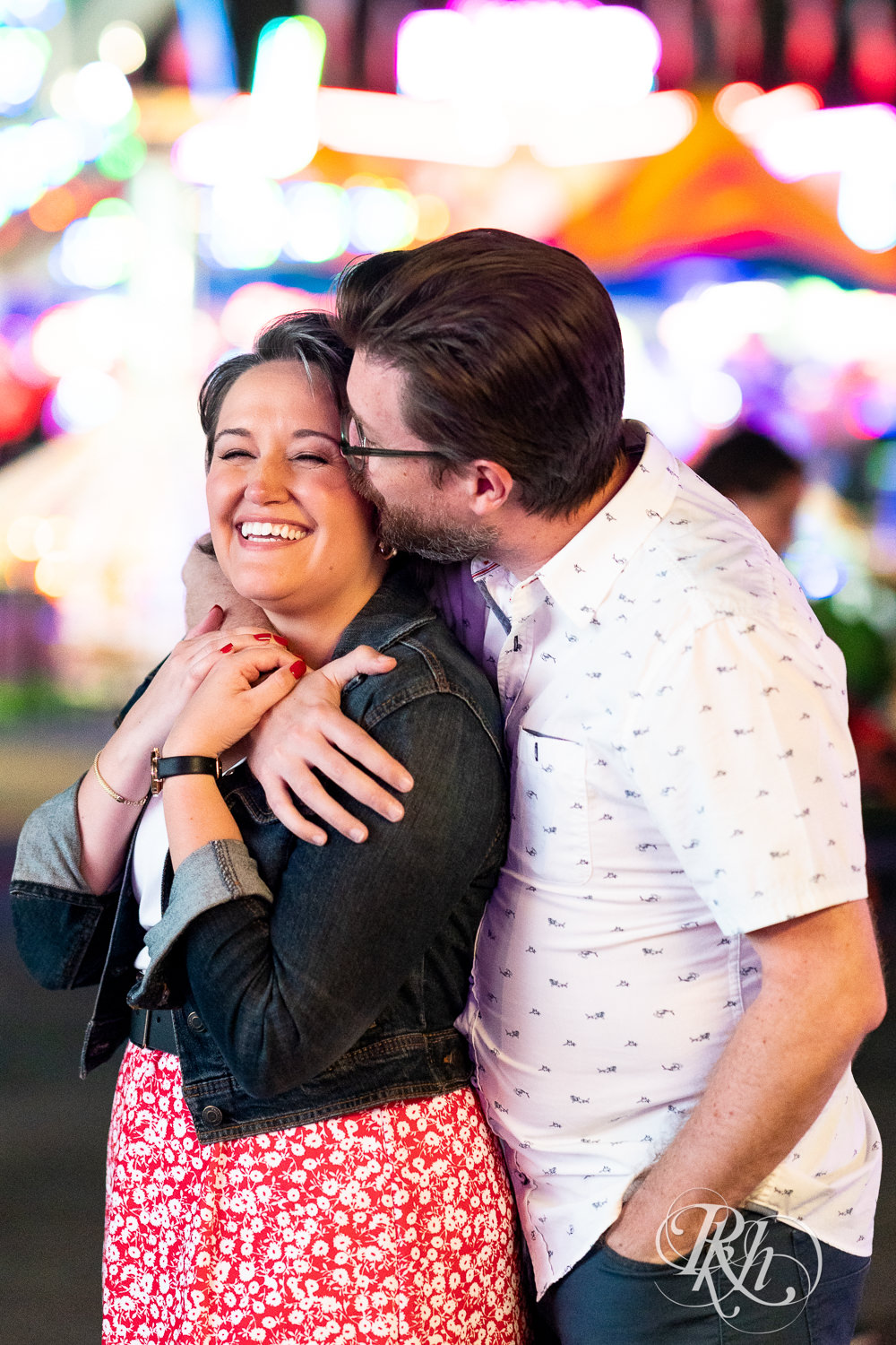 Man and woman kiss during their engagement photography at the Minnesota State Fair. 
