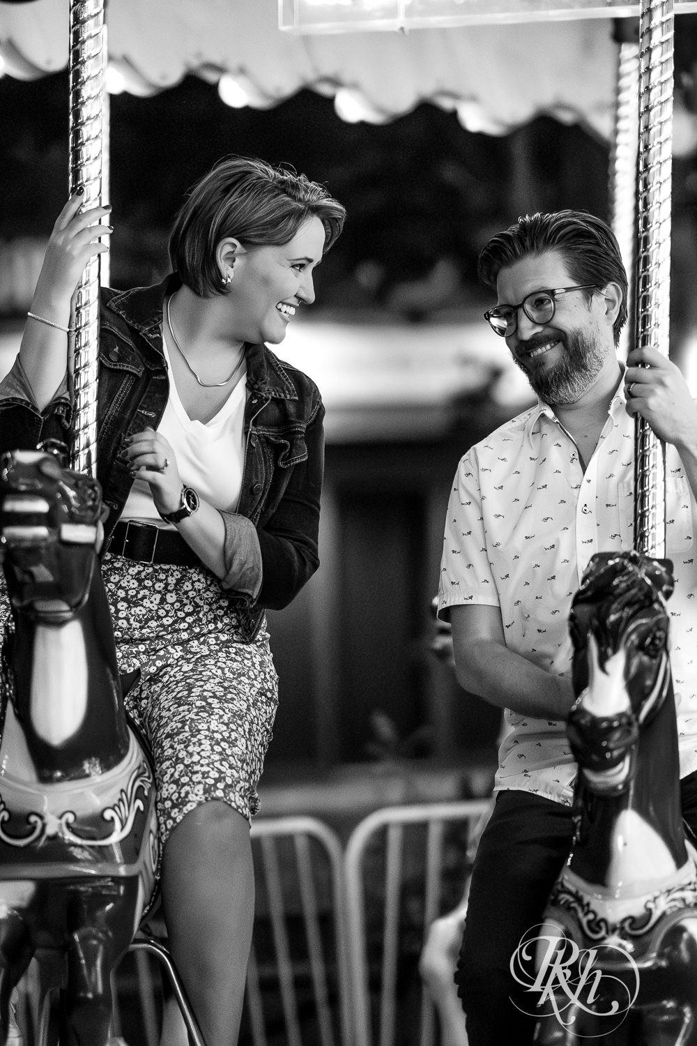 Man and woman ride carousel during their engagement photography at the Minnesota State Fair. 