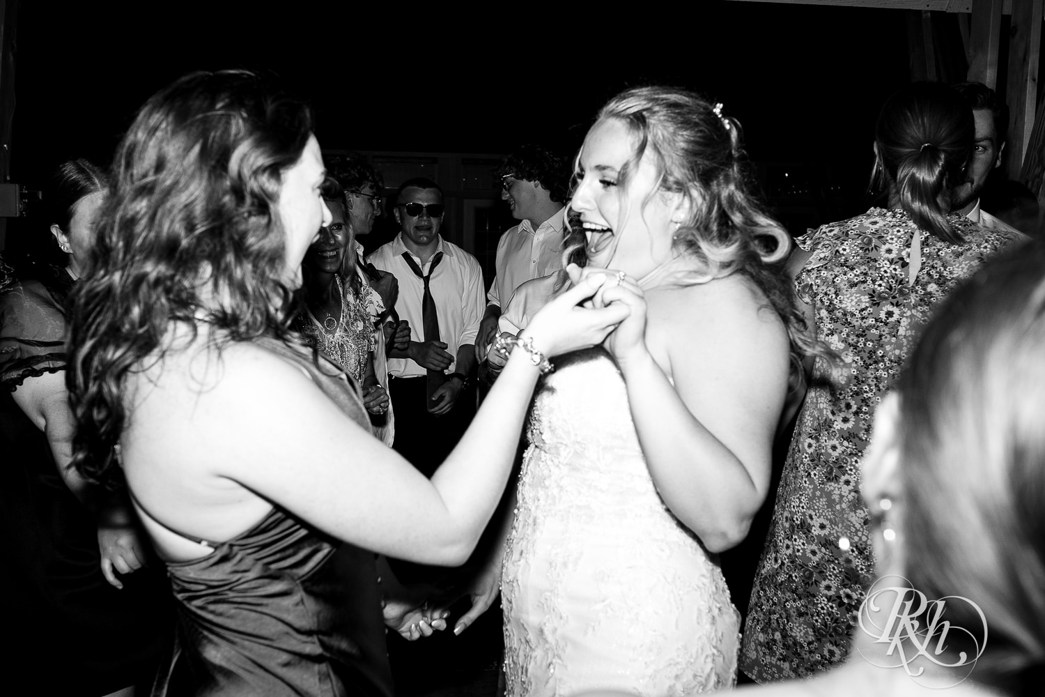 Guests dance with bride during wedding reception at Cottage Farmhouse in Glencoe, Minnesota.