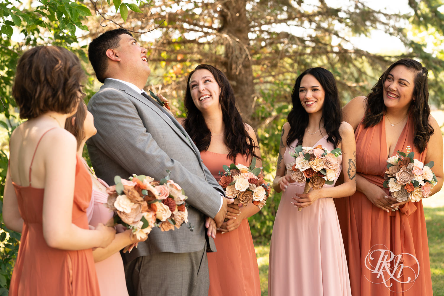 Bride and groom smile with wedding party at Cottage Farmhouse in Glencoe, Minnesota.