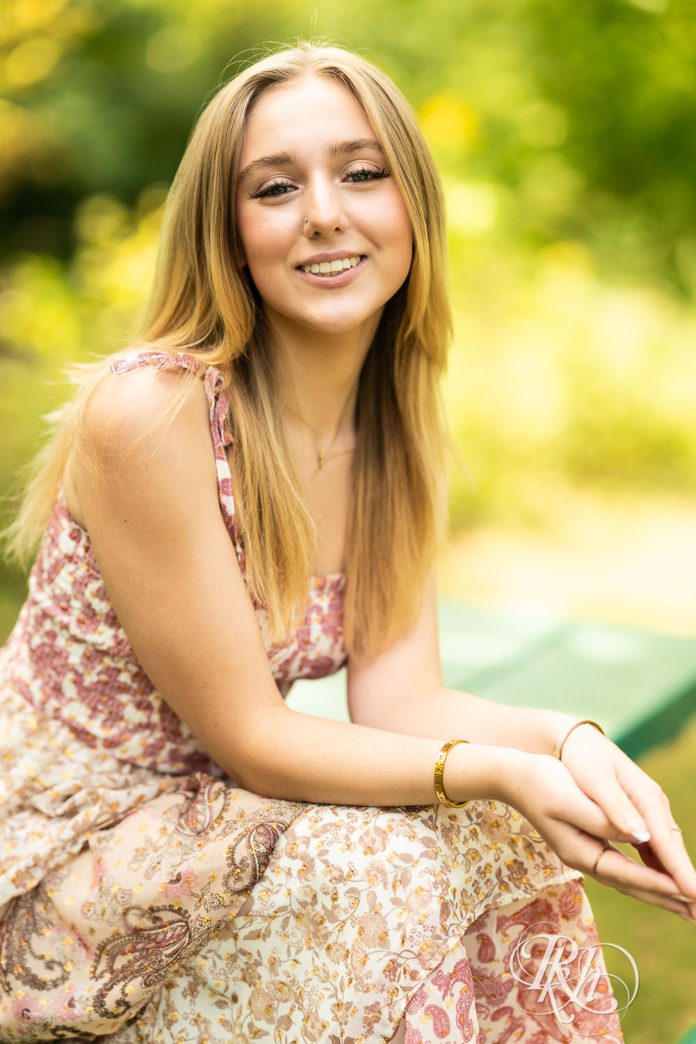 Blond girl in sundress smiles during senior photography in Minnetonka, Minnesota.