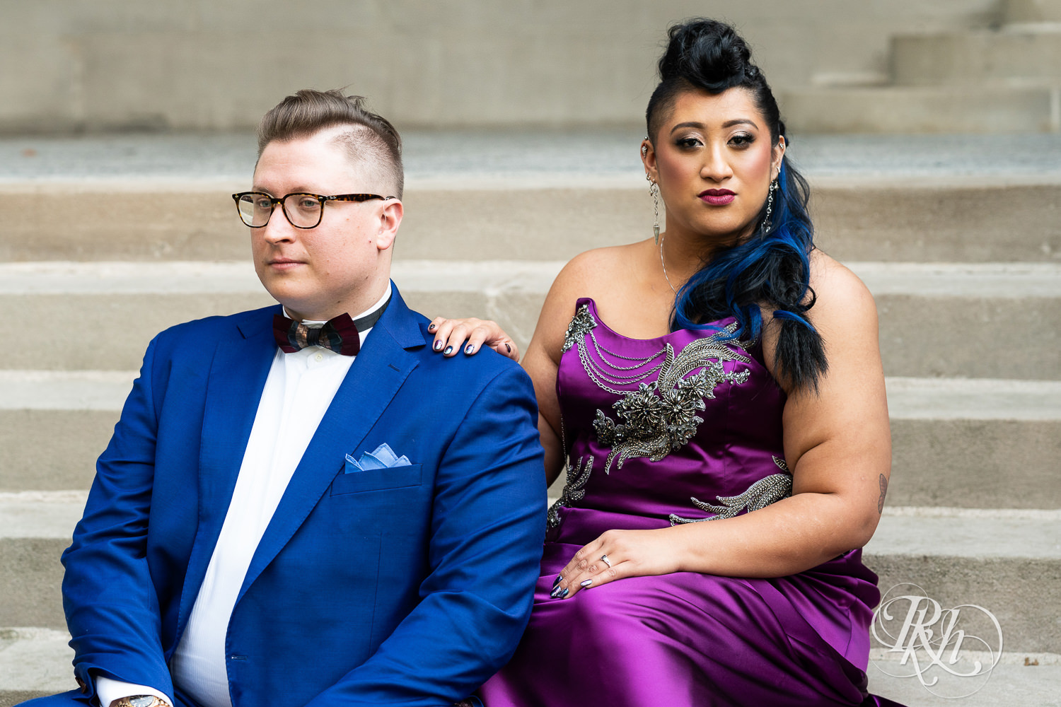 Filipino bride with mohawk dressed in purple wedding dress and groom sit on steps at American Swedish Institute in Minnesota.