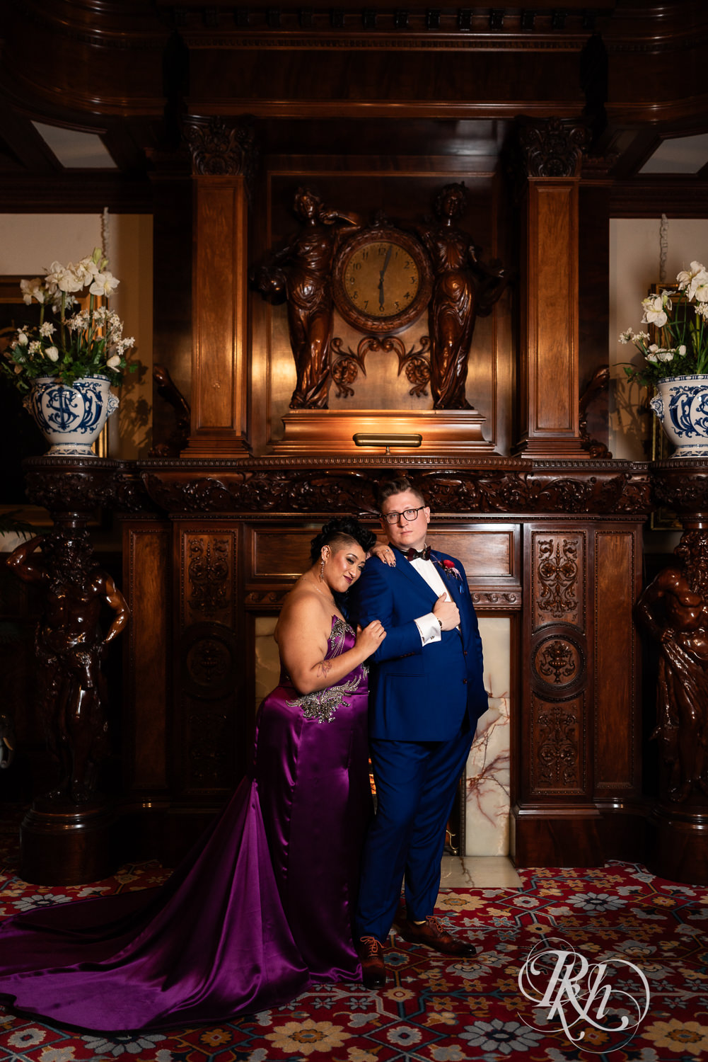 Filipino bride with mohawk dressed in purple wedding dress and groom stand in front of fireplace at American Swedish Institute in Minnesota.