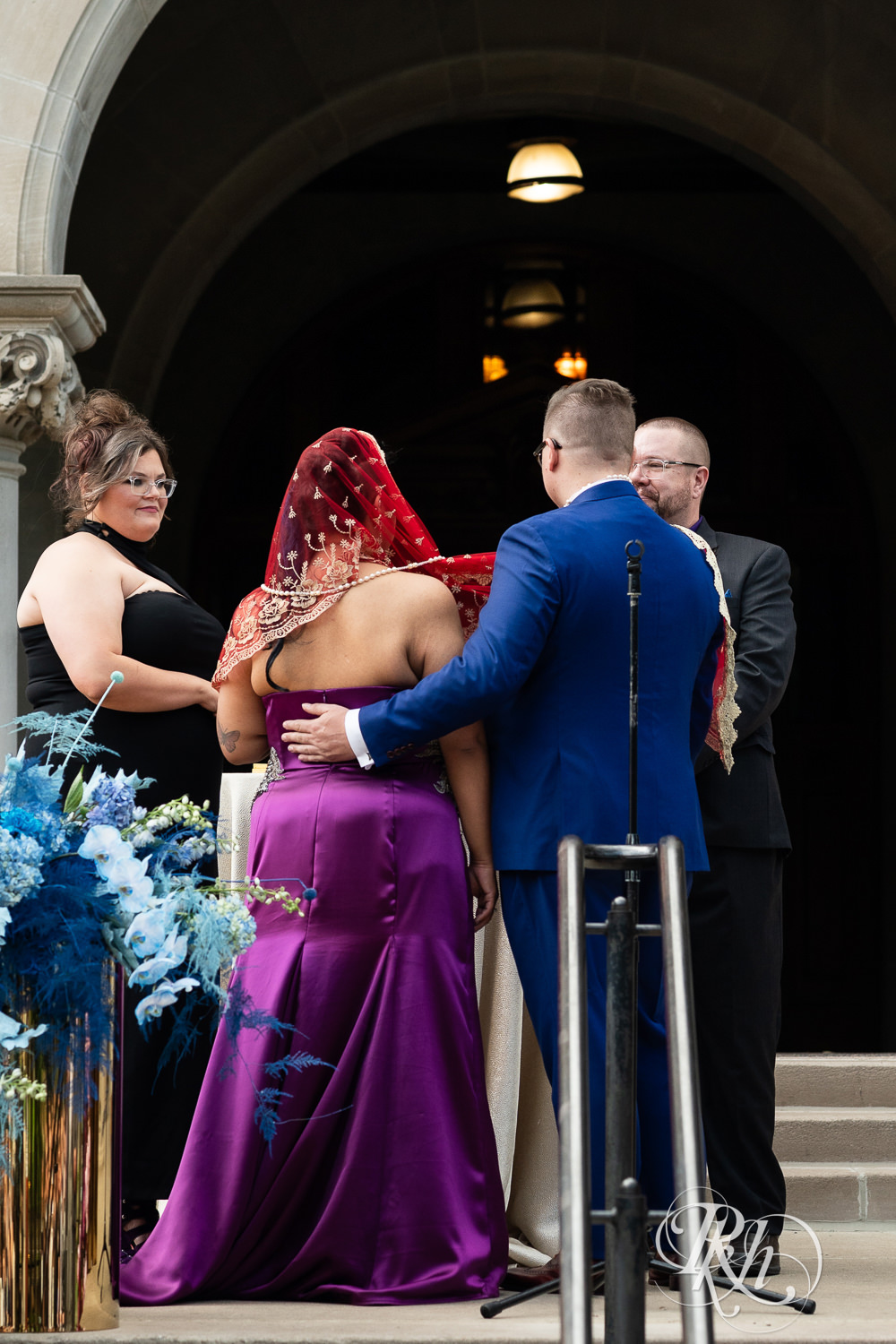 Filipino bride in purple wedding dress and groom hold hands during wedding ceremony at the American Swedish Institute in Minneapolis, Minnesota.