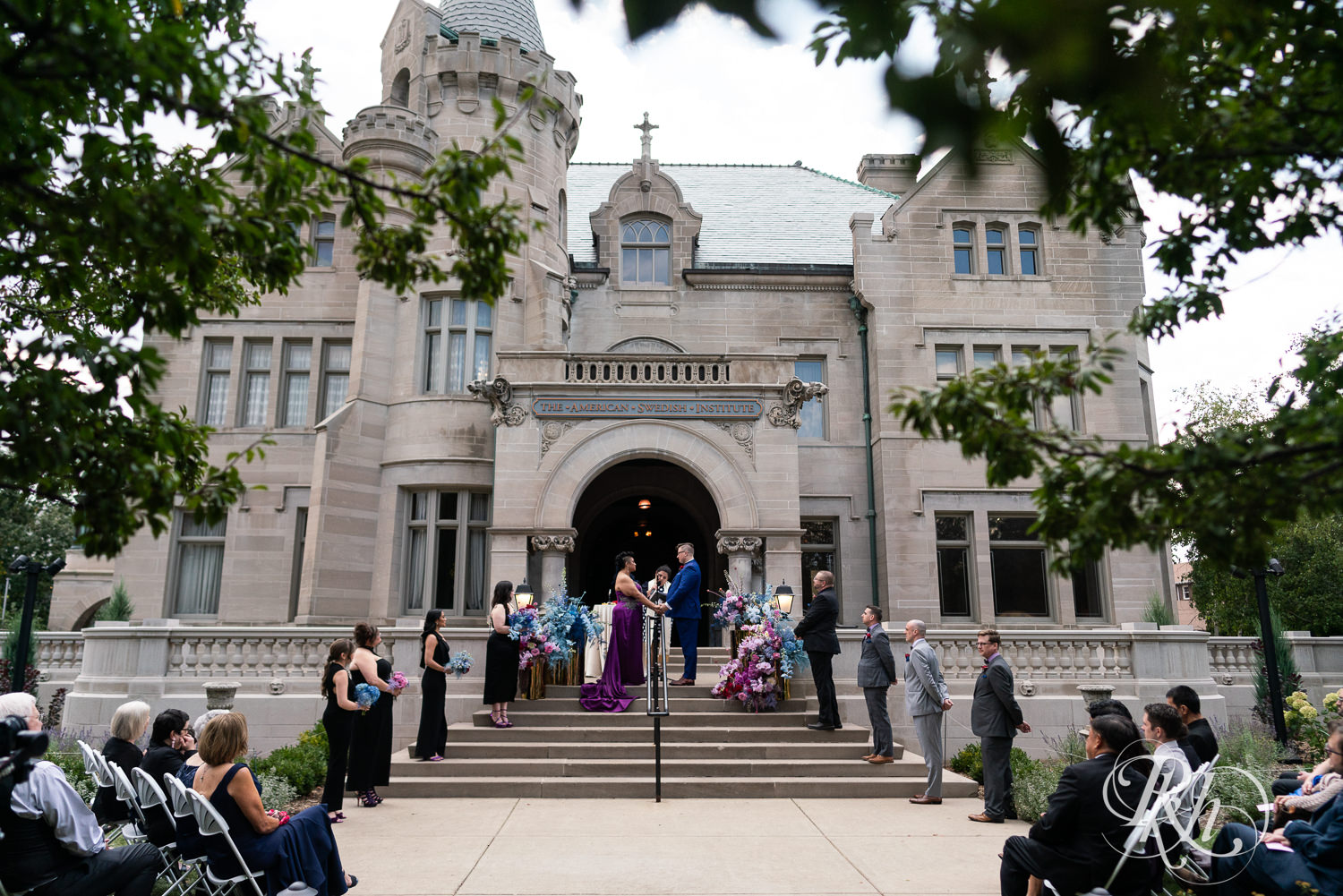 Filipino bride in purple wedding dress and groom hold hands during wedding ceremony at the American Swedish Institute in Minneapolis, Minnesota.