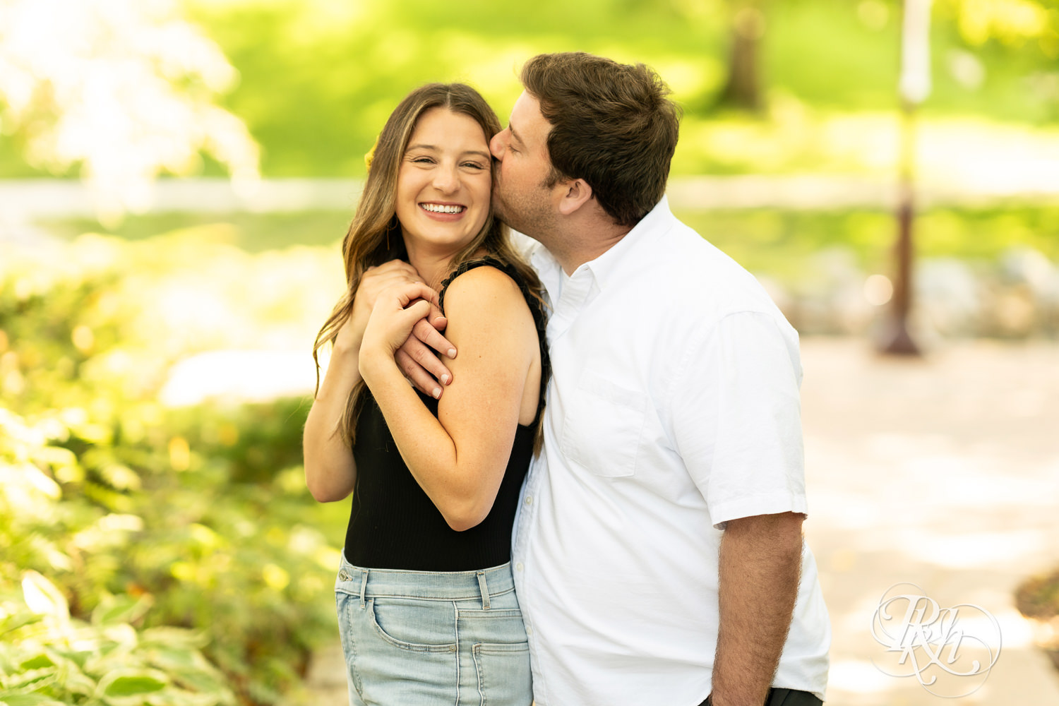 Man and woman smile during engagement photography at Centennial Lakes Park in Edina, Minnesota.