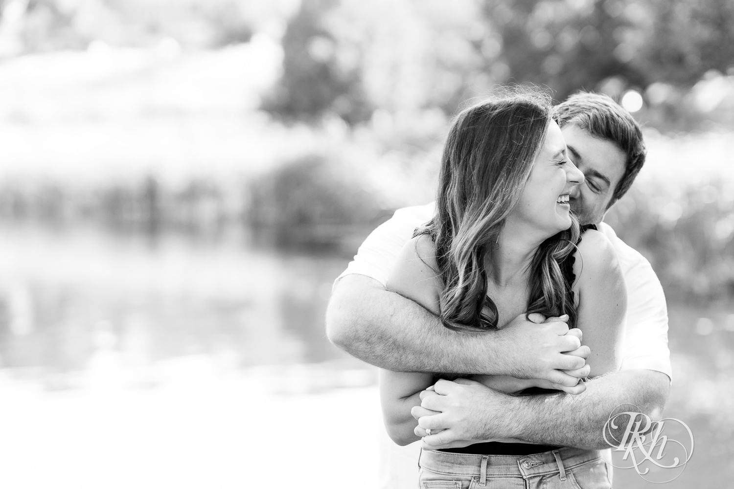 Man and woman laugh during engagement photography at Centennial Lakes Park in Edina, Minnesota.