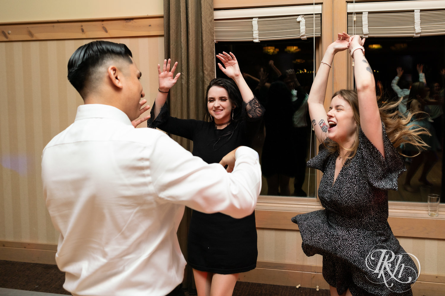 Guests dance with bride and groom during wedding reception at Bunker Hills Event Center in Coon Rapids, Minnesota.