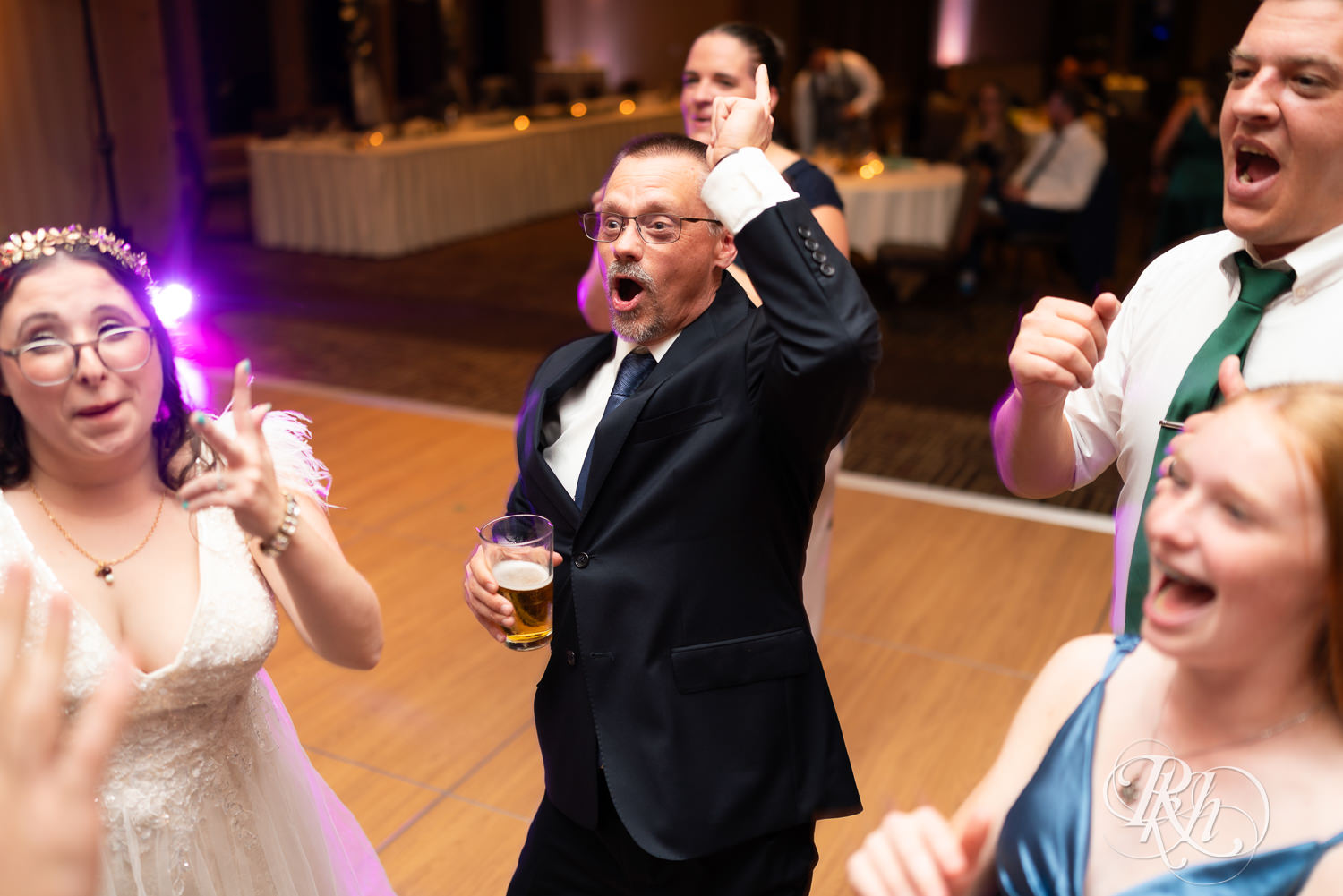 Guests dance with bride and groom during wedding reception at Bunker Hills Event Center in Coon Rapids, Minnesota.