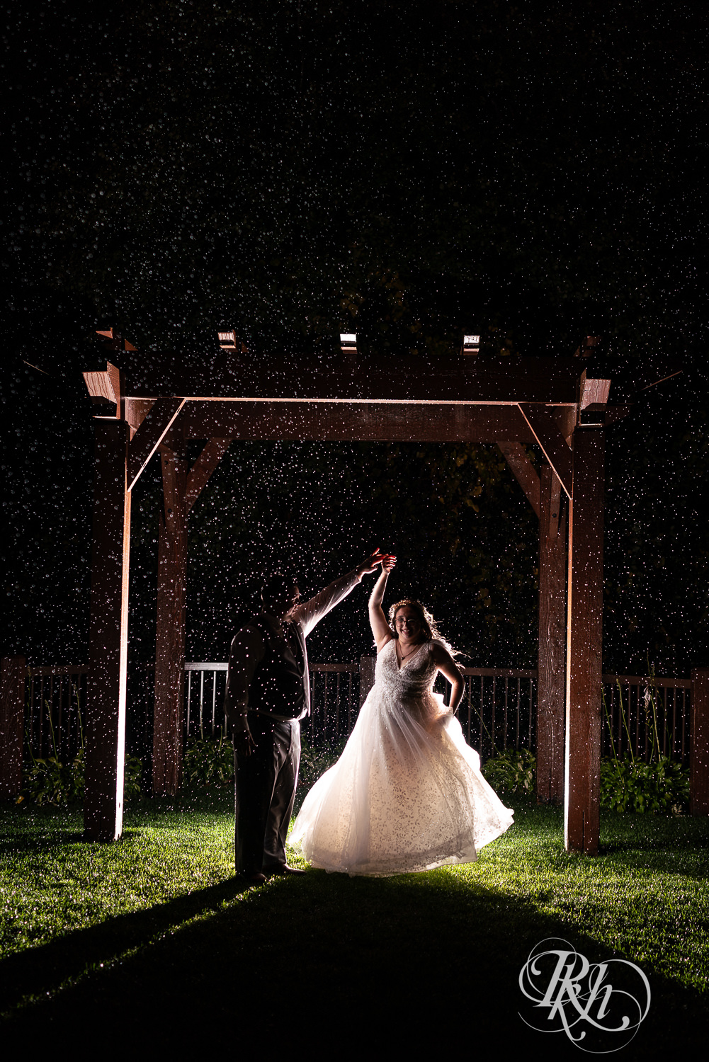 Bride and groom dance in the rain at Bunker Hills Event Center in Coon Rapids, Minnesota.