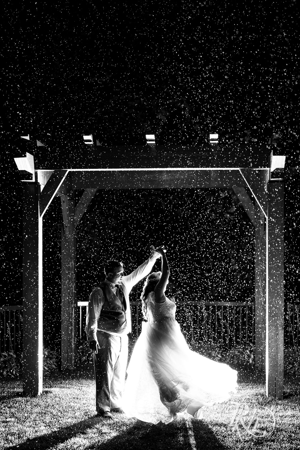 Bride and groom dance in the rain at Bunker Hills Event Center in Coon Rapids, Minnesota.