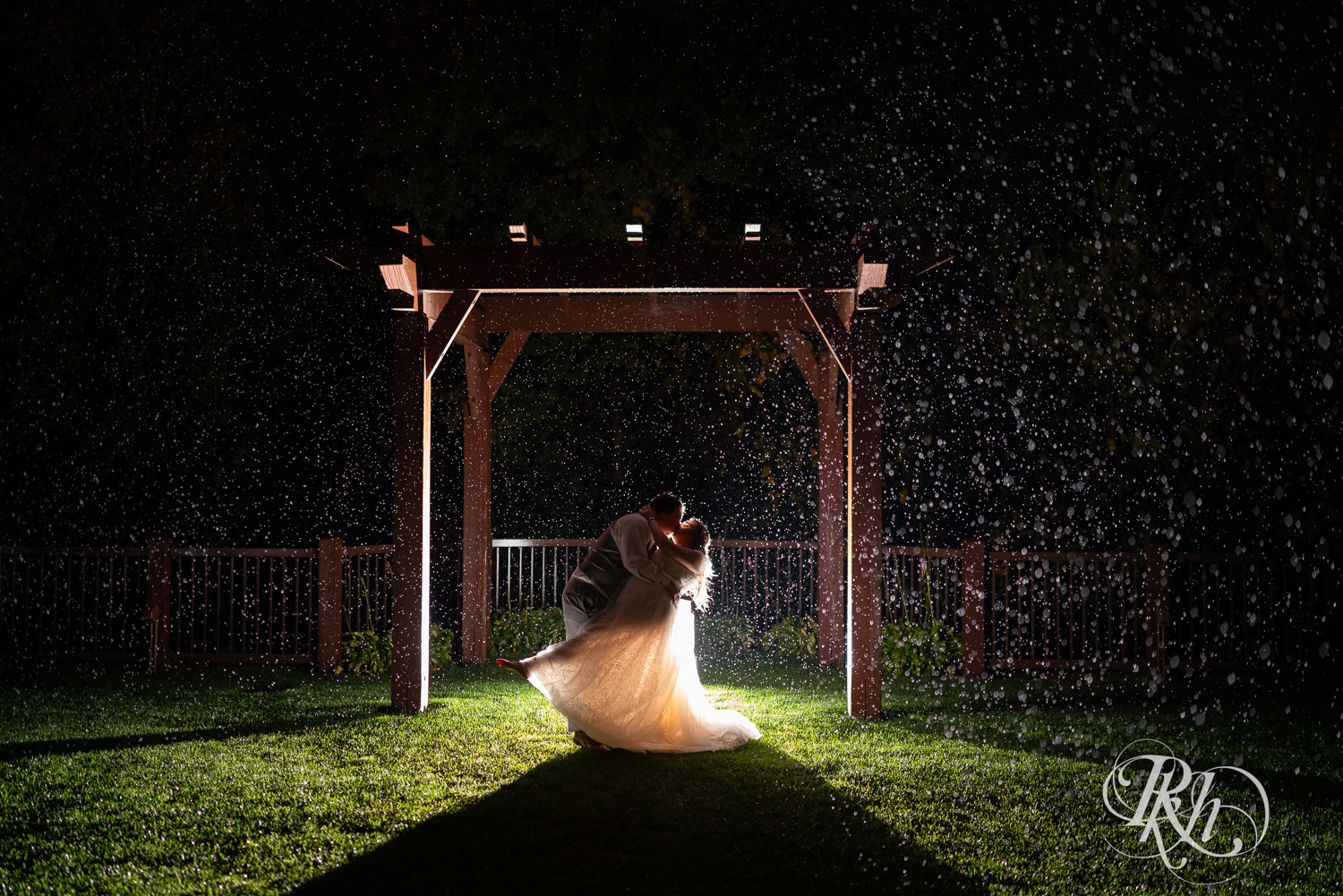Bride and groom kiss in the rain at Bunker Hills Event Center in Coon Rapids, Minnesota.