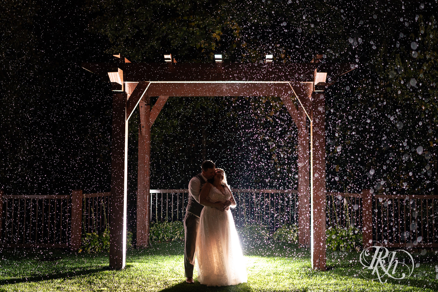 Bride and groom kiss in the rain at Bunker Hills Event Center in Coon Rapids, Minnesota.