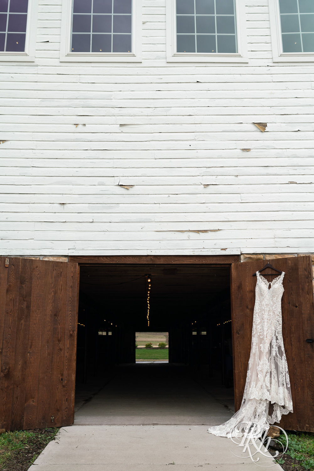 Wedding dress hanging on barn door at Hayvn at Hay River in Boyceville, Wisconsin. 