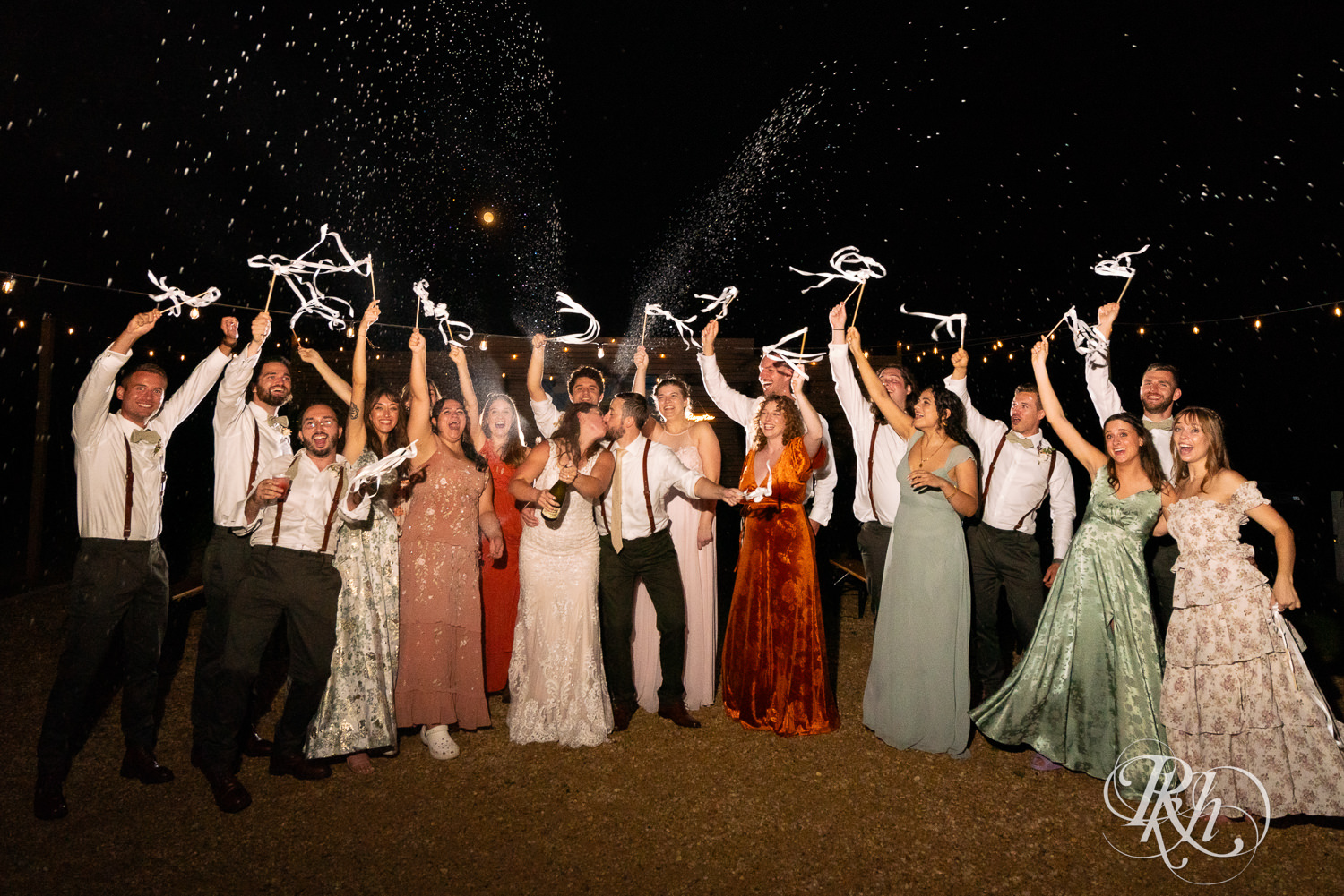 Bride and groom spray champagne with wedding party at Hayvn at Hay River in Boyceville, Wisconsin. 