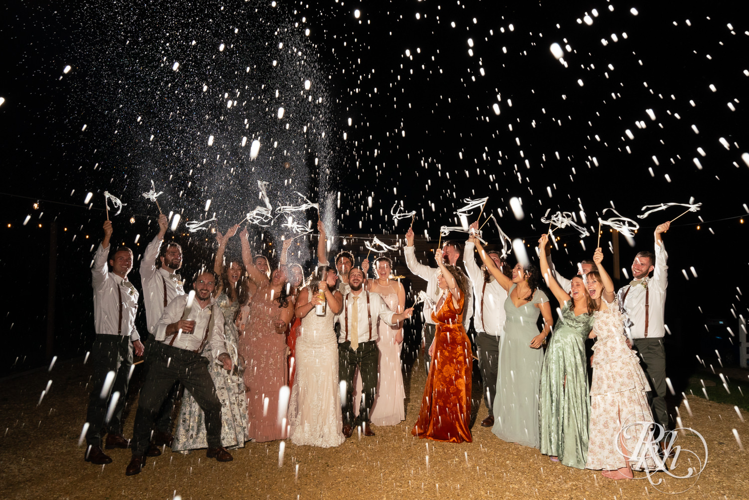 Bride and groom spray champagne with wedding party at Hayvn at Hay River in Boyceville, Wisconsin. 