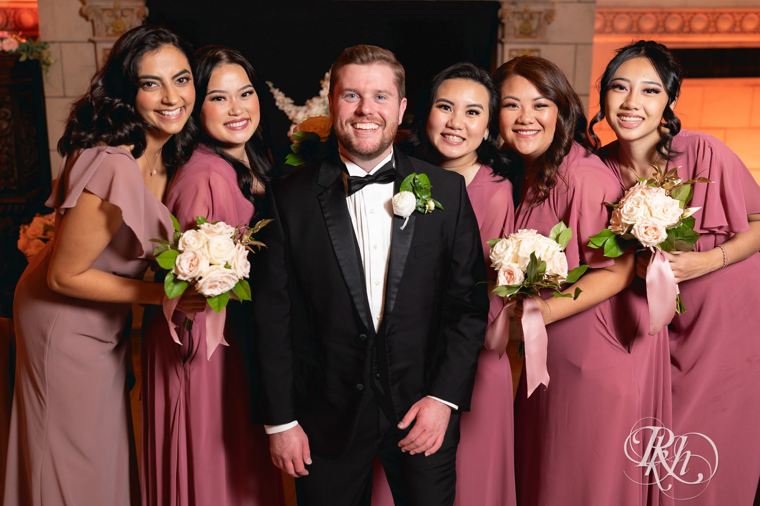 Groom smiles with wedding party at the Saint Paul Athletic Club in Saint Paul, Minnesota.