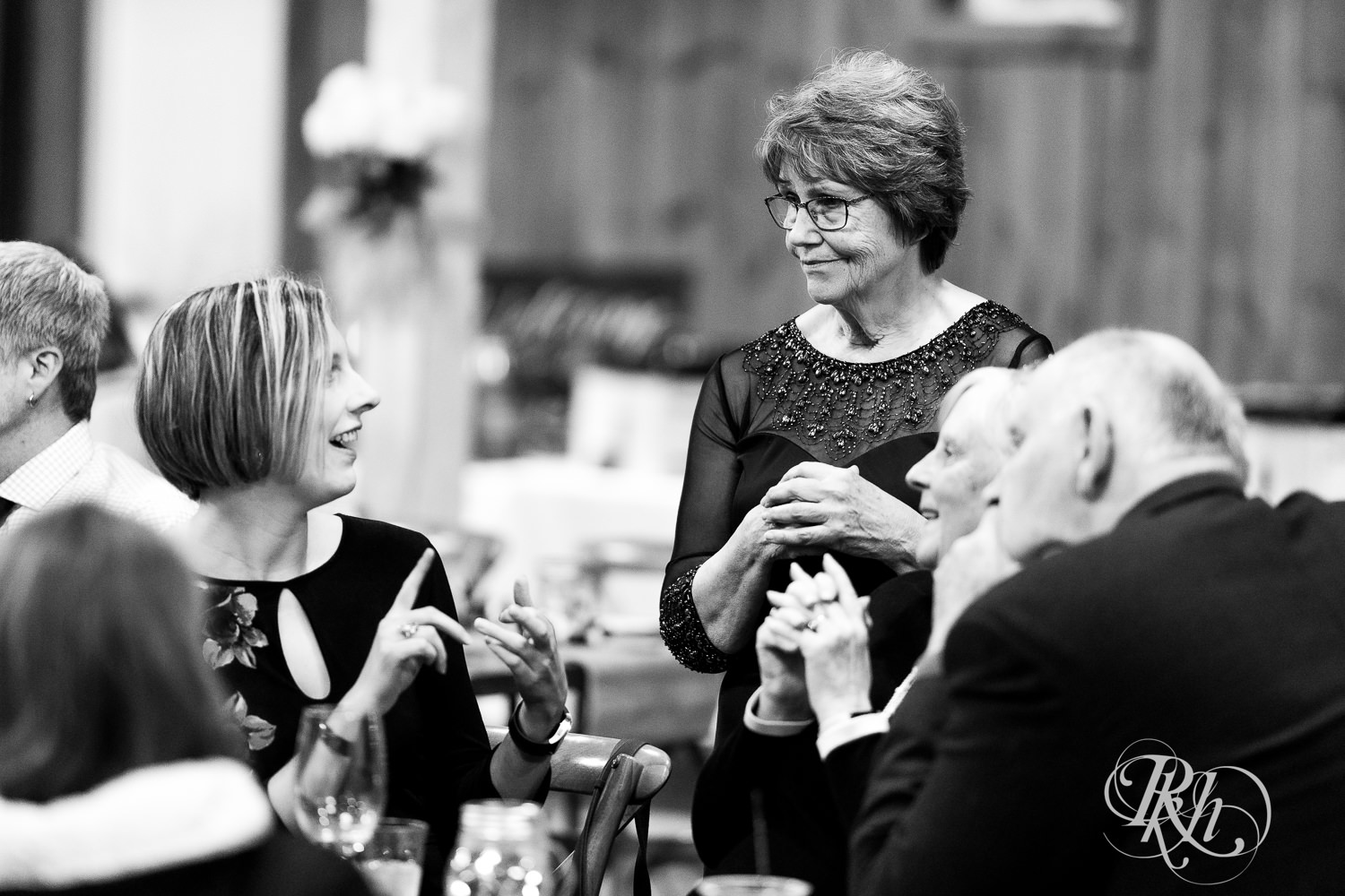 Guests mingle and talk candidly during wedding cocktail hour at Almquist Farm in Hastings, Minnesota.