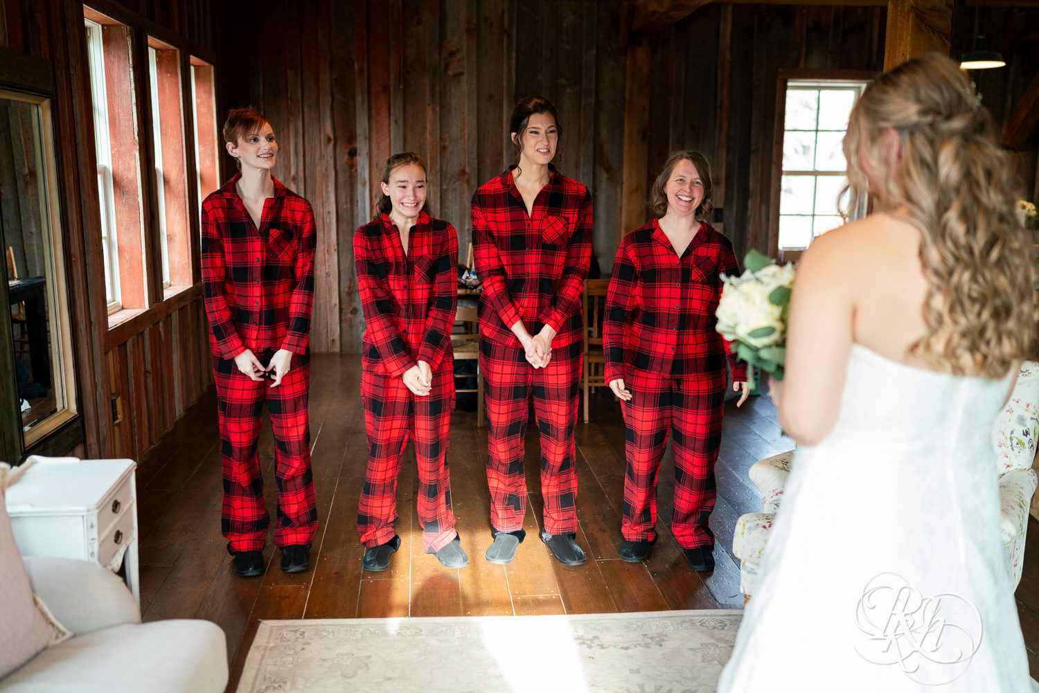 Bride does reveal with bridesmaids in flannel pajamas on wedding day at Almquist Farm in Hastings, Minnesota.