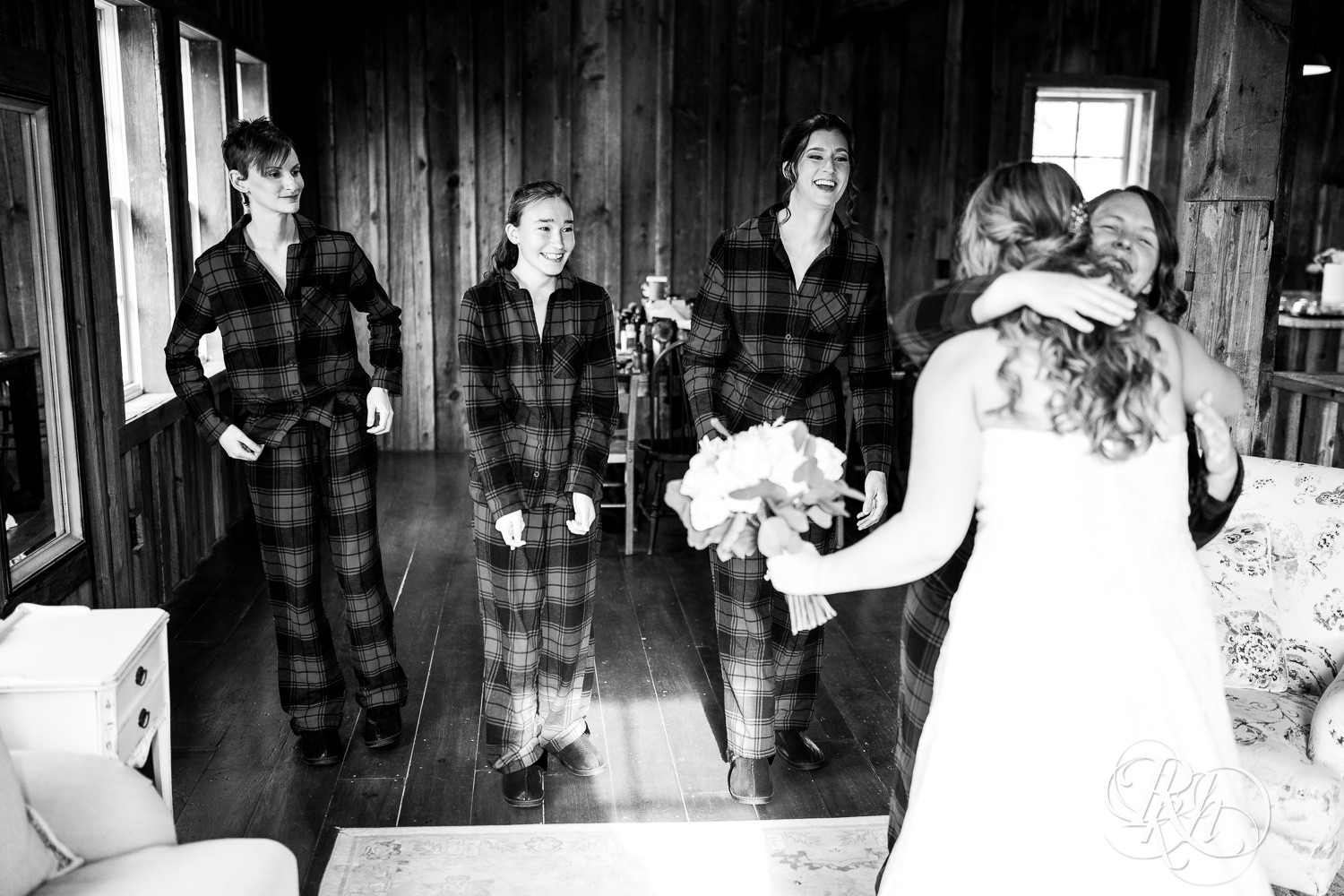 Bride does reveal with bridesmaids in flannel pajamas on wedding day at Almquist Farm in Hastings, Minnesota.