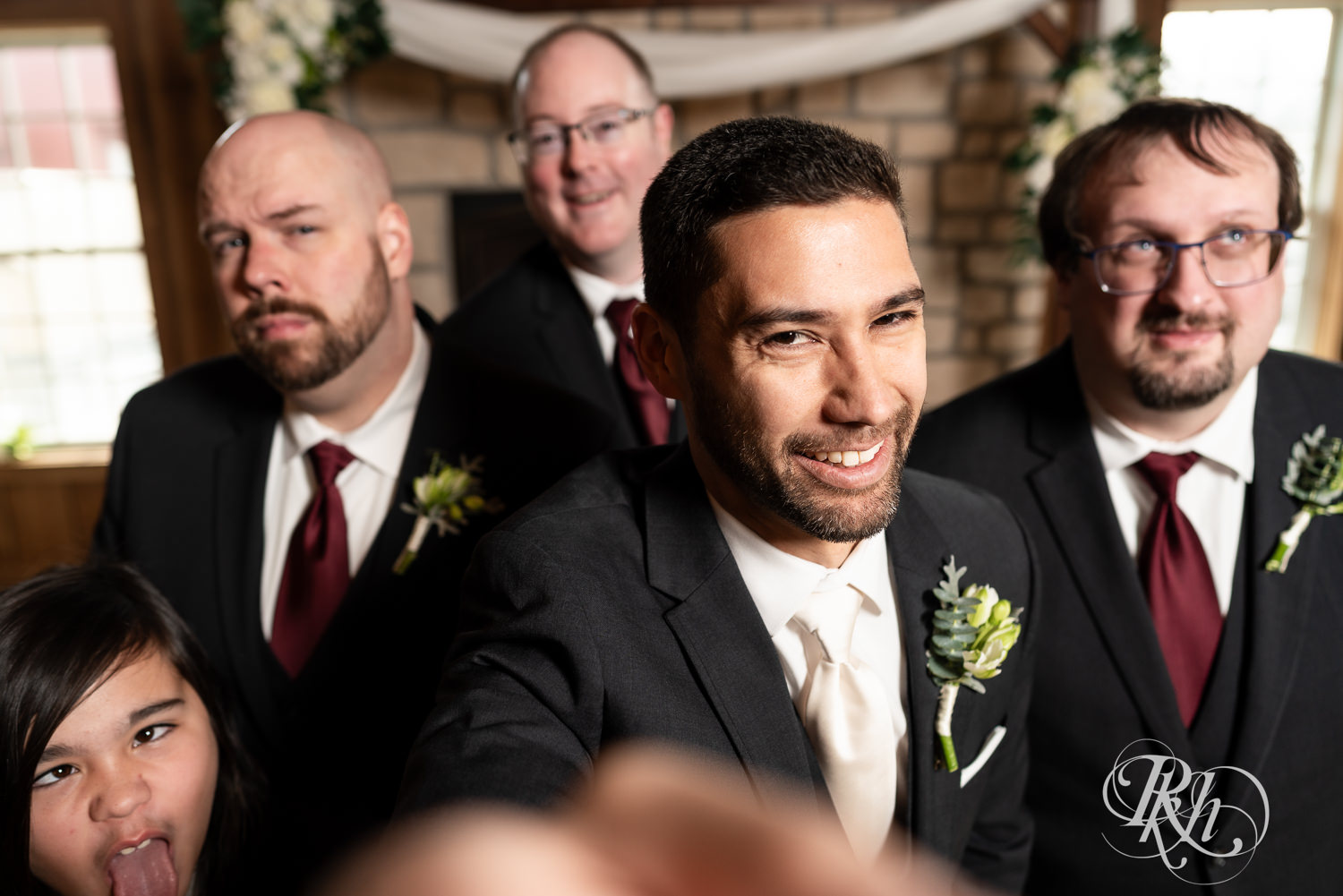 Groom smiles with wedding party at Almquist Farm in Hastings, Minnesota.