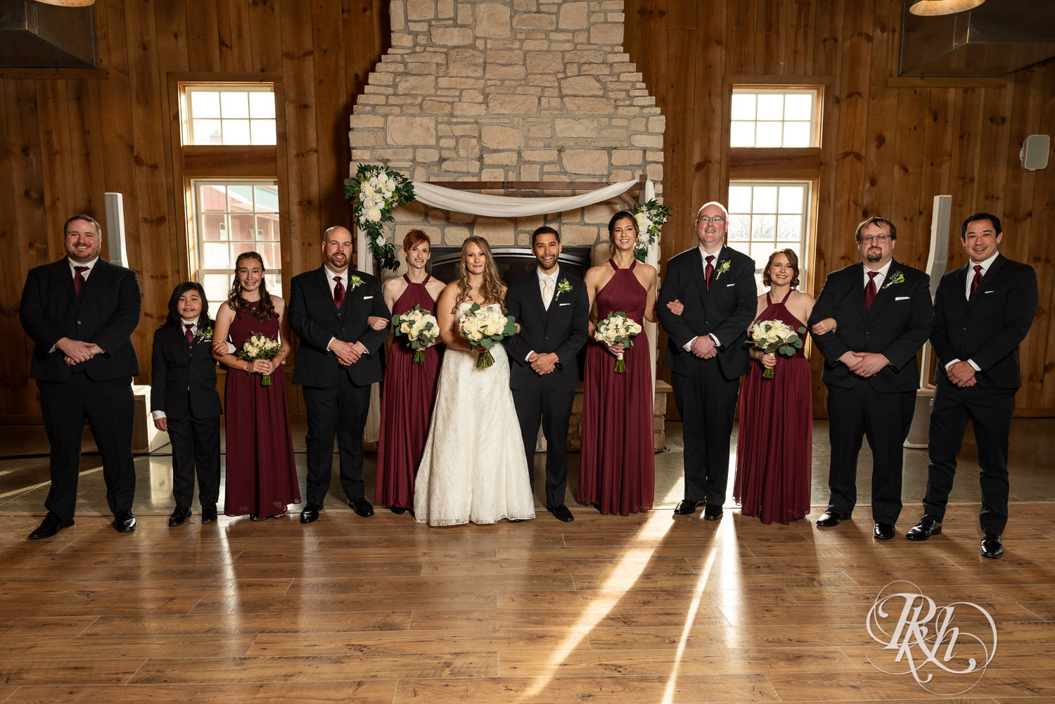 Bride and groom smile with wedding party at Almquist Farm in Hastings, Minnesota.