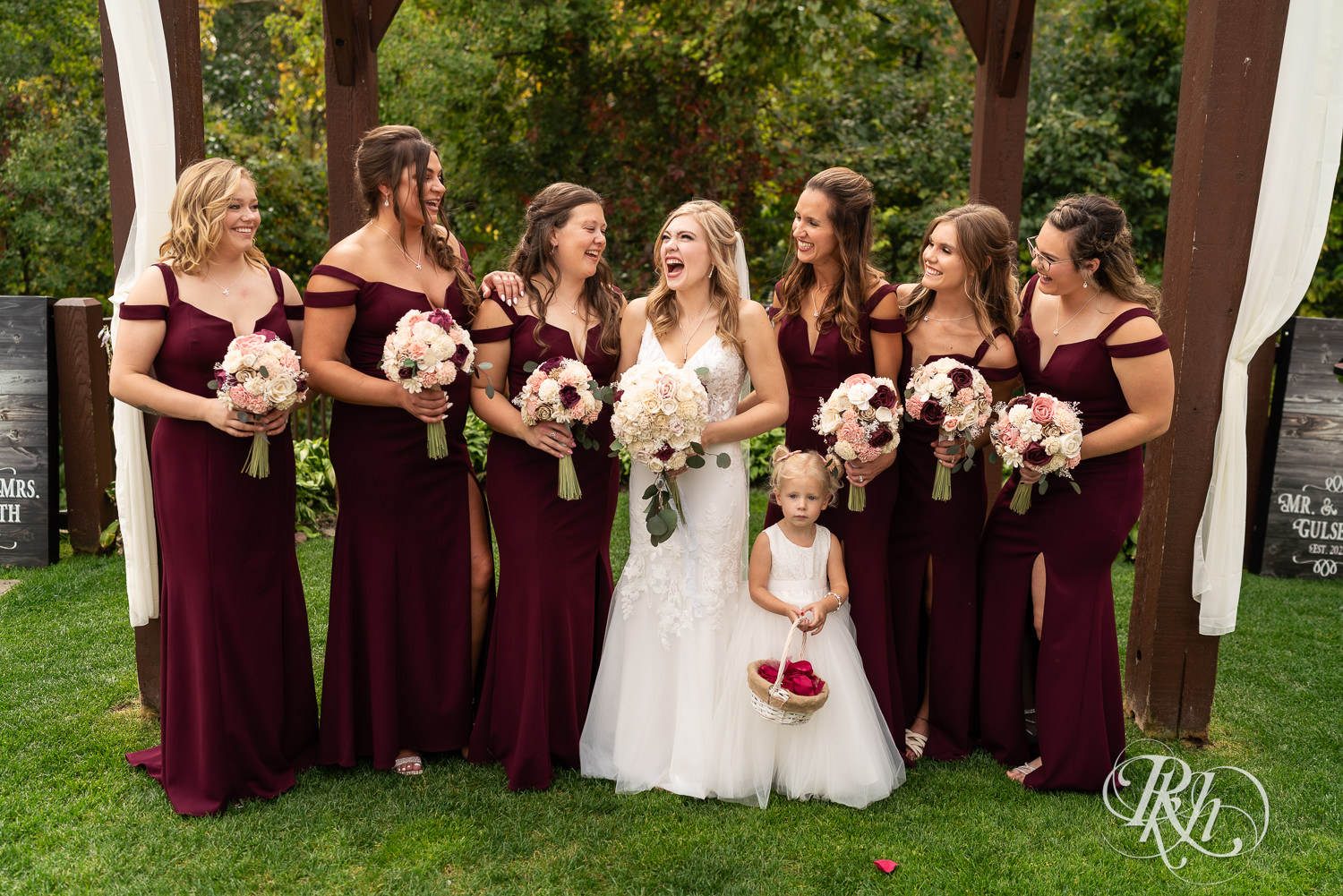 Bride smiles with wedding party at Bunker Hills Event Center in Coon Rapids, Minnesota. 