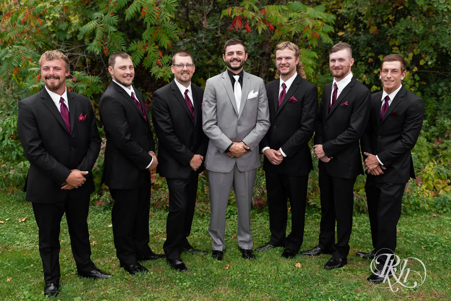 Groom smiles with wedding party at Bunker Hills Event Center in Coon Rapids, Minnesota. 