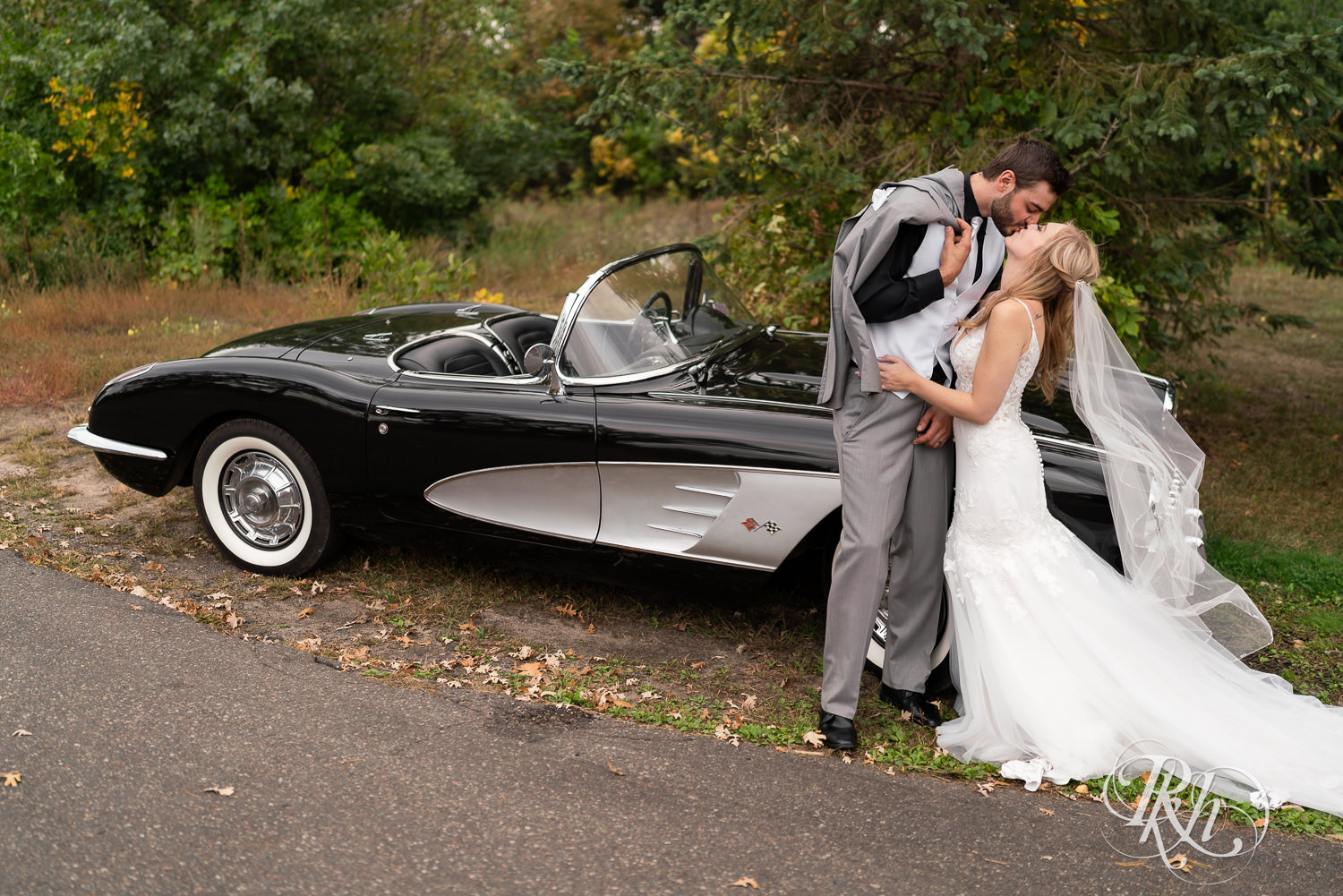 Bride and groom kiss in front of a vintage Corvette at Bunker Hills Event Center in Coon Rapids, Minnesota.